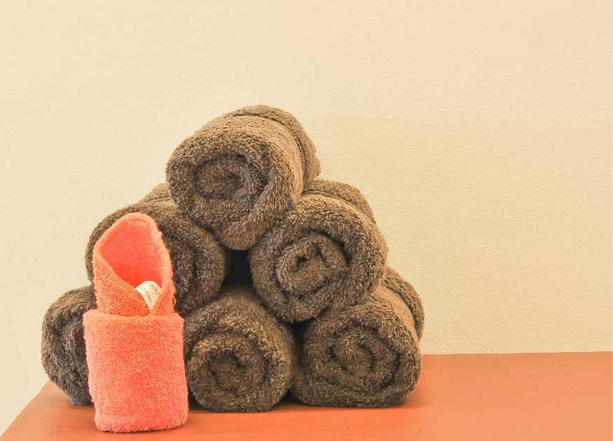 Graphic of a some chocolate coloured rolled towels to represent the linen and towels at The Holt holiday cottage
